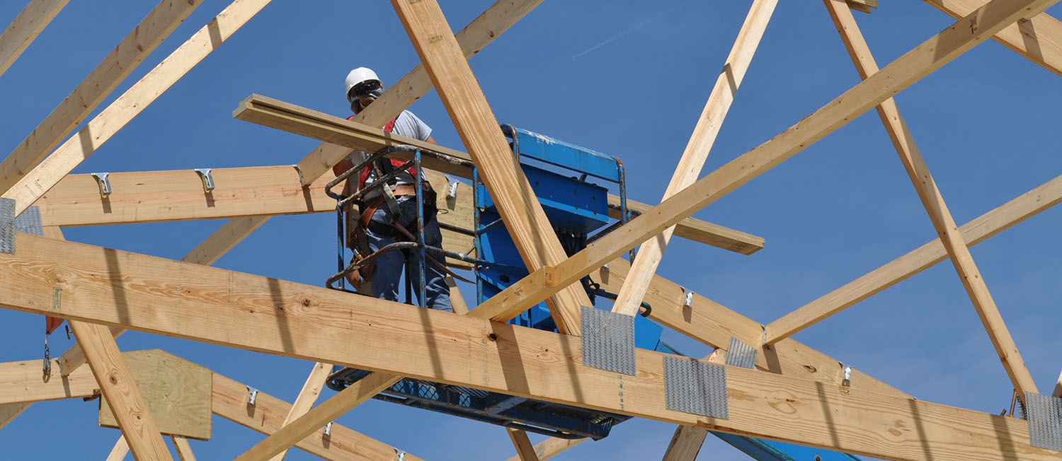 crew member working on post frame roof construction